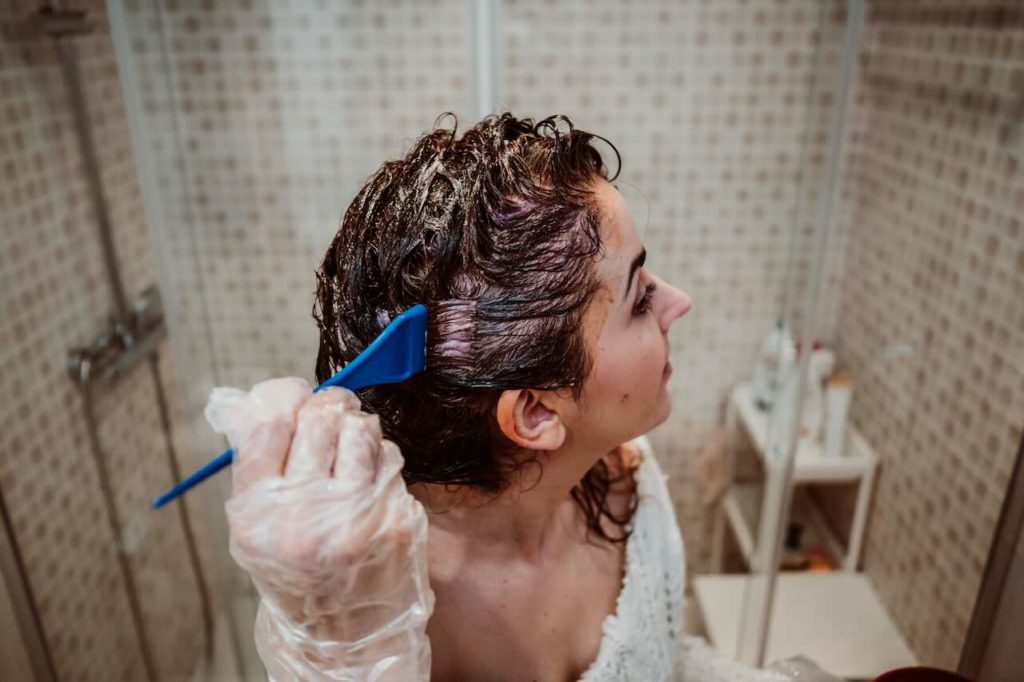 mujer tiñe pelo en casa